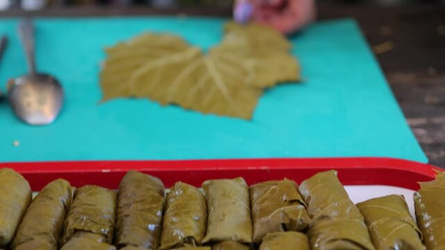 People cook dolma food.
Grape leaves stuffed with minced meat.