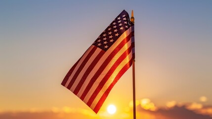 The American flag waves gracefully against a stunning sunset sky, symbolizing freedom and unity, casting a vibrant silhouette in the golden light.
