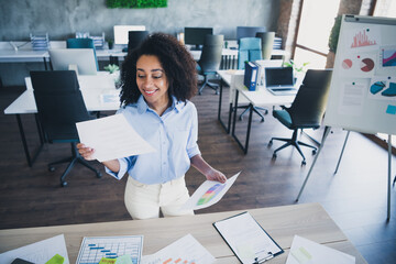 Photo of positive good mood lady specialist dressed shirt reading documents indoors workstation...
