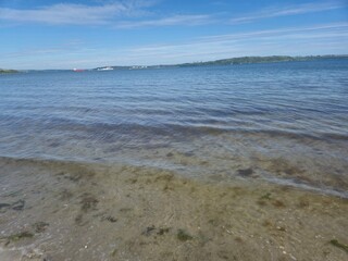 Sunny Summer Day At The Turquoise Shoreline: Waves Gently Breaking On Soft Sand