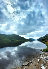 Kylemore Lough in Connemara, Ireland, with its mirror-like waters reflecting the passing clouds. 