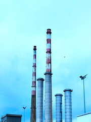 The Poolbeg chimneys in Dublin, featuring the iconic red and white striped smokestacks towering over the city's skyline.