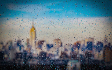 Drops of rain on a window with a city view, New York on the background.