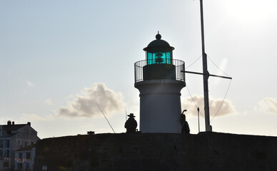 Le pêcheur du phare en contre-jour. avec femme qui dit au revoir en silhouette. Port Joinville, ile d'yeu, vendée, France. 