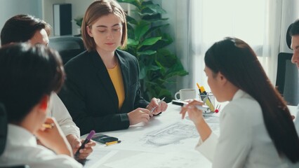 Business woman working and discussing about house model while businessman handed document about architectural model to investor sitting at meeting table with blueprint scattering around. Alimentation.