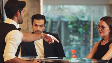 Smiling smart VIP customer inviting friend or couple for sitting at beverage counter bar talking with bartender while preparing welcome drink professionalism making great first impression. Vinosity.