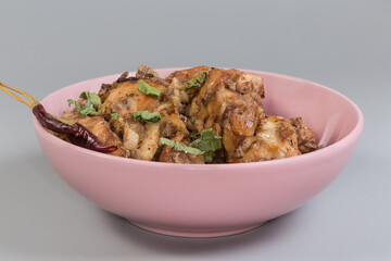 Baked chicken meat in pink bowl, side view close-up