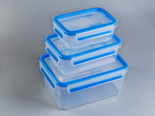 Stacked empty transparent plastic food storage containers different sizes