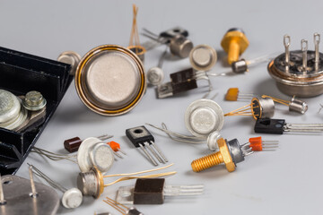 Old transistors various purpose in different packages on gray surface
