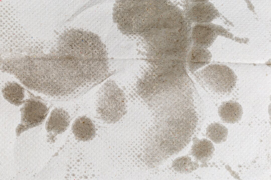 Surface of disposable paper towel with wet footprints, top view