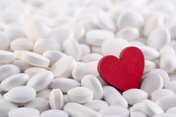 Red heart on heap of many various medicine pills
