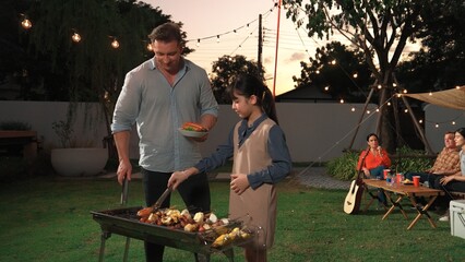 Family celebrate holiday in garden, Father and child grill food for family member. Outdoor camping...