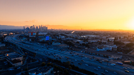 Huge flows of transport moving to and from downtown. Hazy panorama of Los Angeles, California, United States at sunset. Top view.