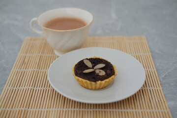Chocolate tart with almond on white plate. Selective focus.