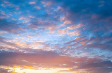 Sunset sky background in picturesque colors, dramatic sunset sky in pastel tones, vast panoramic sunset sky with colorful clouds