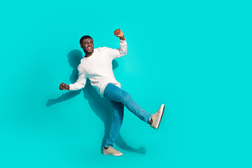 Full body photo of attractive young man dance have fun dressed stylish white clothes isolated on cyan color background