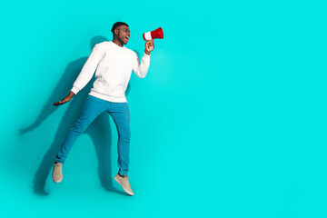 Full body photo of attractive young man jump toa announce empty space dressed stylish white clothes isolated on cyan color background