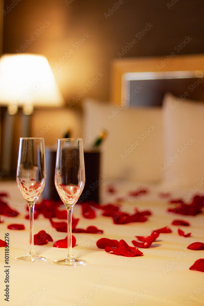 Wall mural a romantic hotel room setting with a chilled bottle of champagne and two glasses on a table, adorned