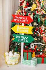 Stylish funny bright and colorful Christmas interior with yellow, red and green decorations. Children room in New Year decoration. Pointer where is the village of Santa Claus