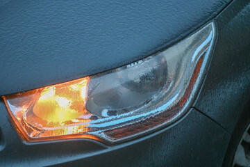 Gros plan sur un phare et un clignotant de voiture recouverts de gel et de glace en hiver © Jean-Marc RICHARD