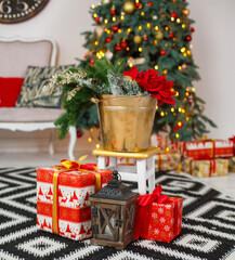 Christmas presents/gifts under fir-tree. Vintage New Year decorations. Red gift boxes and lantern under fir-tree on dark wooden flor. Christmas mood. Celebrating of New Year