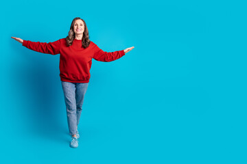 Full body portrait of nice aged woman walk arms wings wear sweater isolated on blue color background
