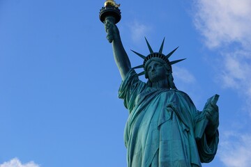 Fototapeta premium Close Up Seiten Profil von der Freiheitsstatue in New York, die die Fackel der Freiheit vor strahlendem blauen Himmel hochhält; amerikanische Sehenswürdigkeit