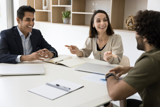 Confident mature Hispanic businesswoman leader ceo hold negotiations with men investors business partners. Happy aged Latin lady business coach trainer lead workshop multicultural employees seminar