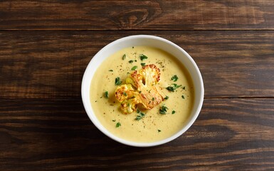 Cauliflower cheese soup on wooden background