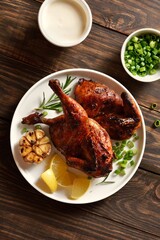 Roasted half chicken with sauce on wooden background