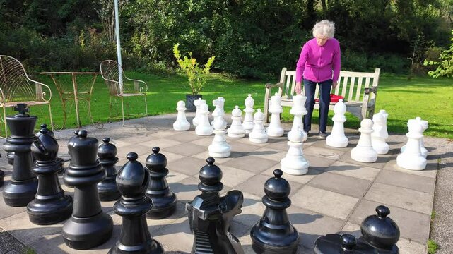 Devon, England UK.  30.09.2024. Video. vlandscape, view, An elderly dementia sufferer playing on a giant chess board in Devon UK.