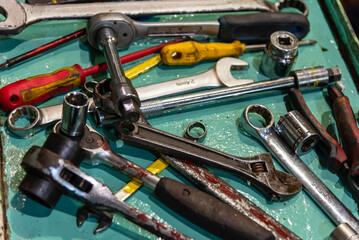 A close-up of various tools scattered across a work platform in the ship's engine room, each essential for the maintenance and repair of the main engine on a merchant vessel.