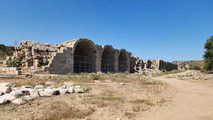 Fototapeta premium Arched stone buildiings in the eastern side of the stadium of the Perge ancient city located in Aksu district of Antalya province in Turkey