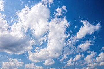 A beautiful daytime sky scene featuring a rich blue background dotted with puffy white cumulus...