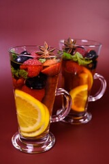 hot fruit drink with berries in a tall glass glass. Punch, mulled wine, alcoholic cocktail