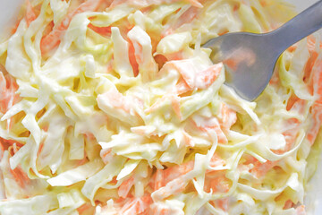 Coleslaw salad with carrot and cabbage on fork. 