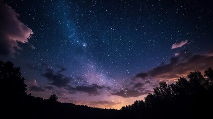 Fototapeta premium The dark night sky, filled with twinkling stars and a few fluffy clouds.