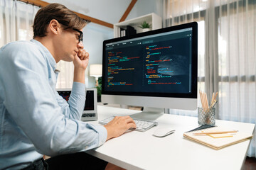 IT developer working online software development information on pc and laptop screen with typing to create new code program on updated version application project creating overall system. Pecuniary.