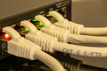 Close up on network switch with several lights on and network cables plugged in. Depth of field...
