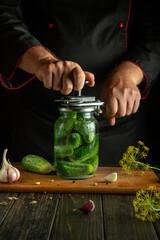 Making pickled cucumbers. The cucumbers are rolled up by the cook hands in a jar with spices for long-term storage.