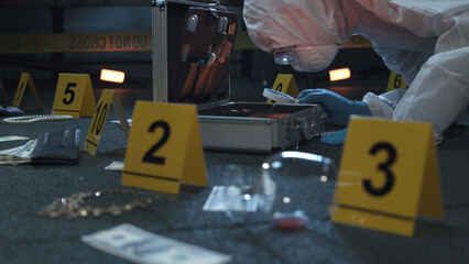 Forensic expert working at crime scene of failed robbery of wealthy apartment. Lots of evidence tags, aluminum tool case. Night time. 