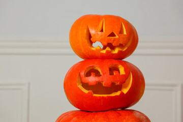 Three stacked jack-o-lanterns with carved faces for Halloween