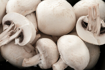 Close up of a pile of mushrooms on dark background.