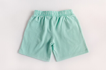 Mokup of turquoise trunk shorts on the white background. Top view. Back view