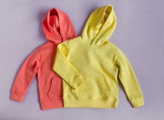 Yellow and red hoodies on the purple background. Set of clothes, template for design, mokeup. Flat lay, top view