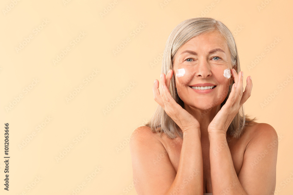 Poster Senior woman with face cream on beige background. Space for text