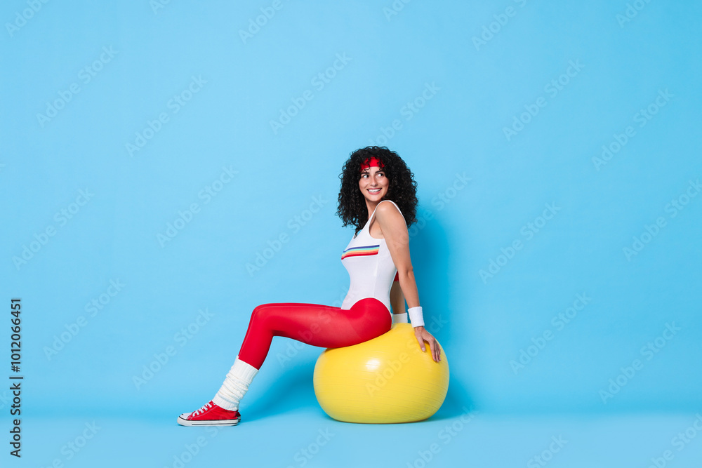 Poster Aerobics. Happy woman with fitness ball on light blue background