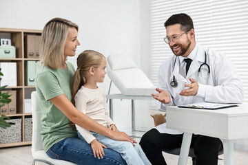 Fototapeta premium Doctor consulting little girl and her mother in hospital