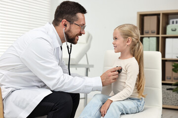 Obraz premium Doctor examining little girl with stethoscope in hospital