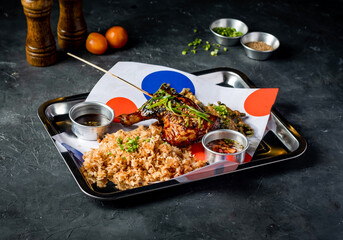 Grilled Chicken Leg Quarter with Garlic Rice, tomato, and Sauces served in tray dish isolated on grey background side view of platter meal